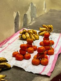 Close-up of orange fruits on table against wall