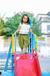 Full length of girl walking on slide in playground