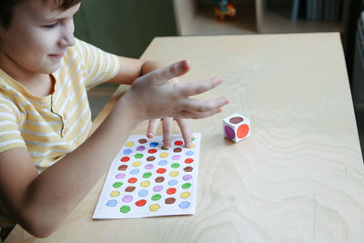 Child playing diy dot game for fingers. useful game for development of childs fingers