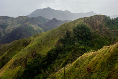 Scenic view of green mountains against sky