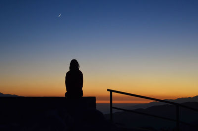 Silhouette man against moon at sunset