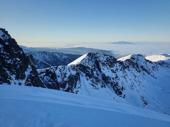 Scenic view of snowcapped mountains against clear sky