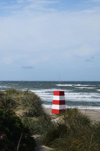 Lifeguard hut on beach against sky