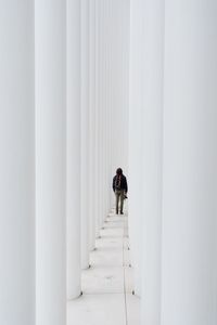 Rear view of man walking in corridor