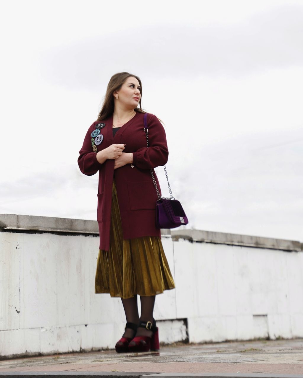 YOUNG WOMAN LOOKING AWAY AGAINST SKY