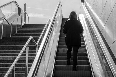 High angle view of woman walking on escalator