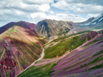 Scenic view of mountain range against cloudy sky