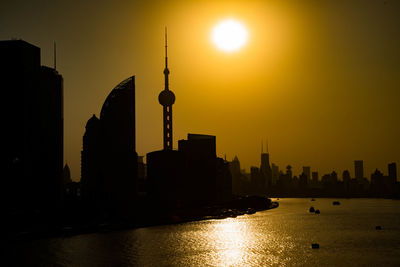 Silhouette of buildings against sky during sunset