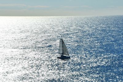 Sailboat sailing on sea against sky