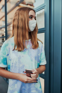 Girl wearing mask standing outdoors