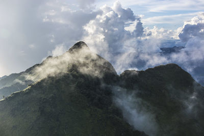 Scenic view of mountains against cloudy sky