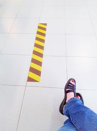 Low section of woman standing on tiled floor