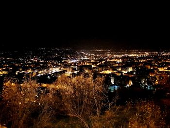 Illuminated cityscape against sky at night