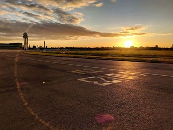 View of airport runway against sky during sunset