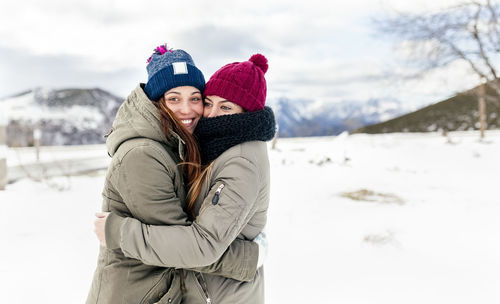 Two young women hugging in the snow