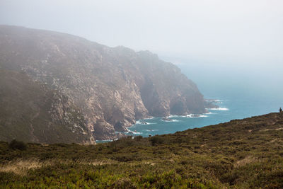 Scenic view of sea and mountains against sky