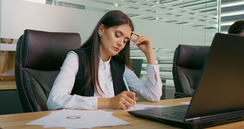 Businesswoman is overwhelmed and feels stressed out at workplace. 