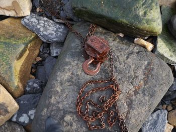 High angle view of rusty chain on rock