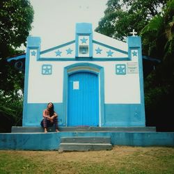 Woman sitting at entrance of building
