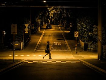 Woman walking on road at night