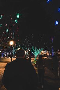 Rear view of men in city at night