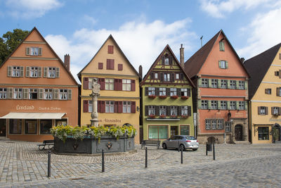 Houses by street in town against sky