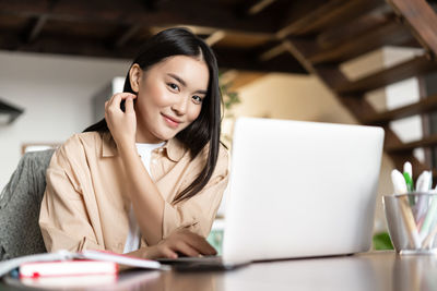 Young businesswoman using laptop at table