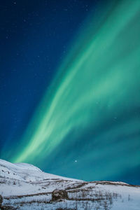 Snowy hills under northern lights landscape photo