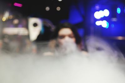 Defocused image of woman lying on illuminated floor