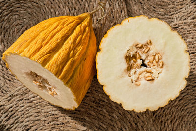 Cut in half turkish local yellow melon on straw deck, organic fruit market advertising idea