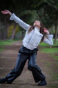 Full length of young woman standing on road