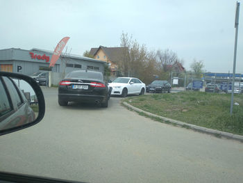 Cars on street in city against clear sky