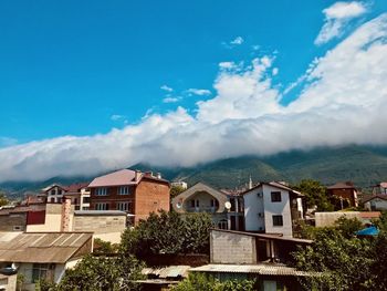 Houses and buildings in town against sky