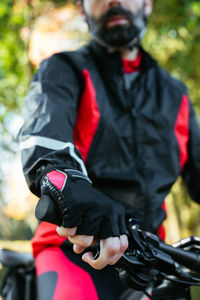 Rear view of man with bicycle leaning against blurred background