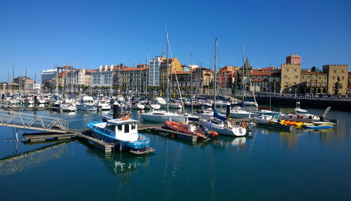 Boats moored at harbor in city