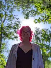 Low angle view of woman standing against tree