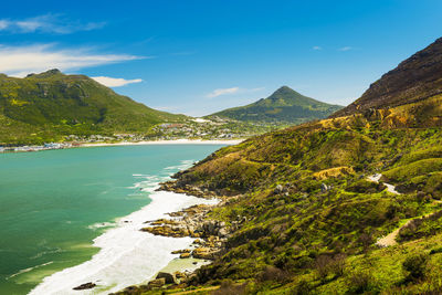 Scenic view of sea and mountains against blue sky