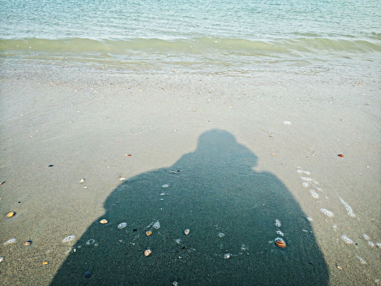 water, beach, sea, shore, high angle view, sand, lifestyles, leisure activity, wave, men, surf, nature, vacations, sunlight, outdoors, unrecognizable person, day, tranquility