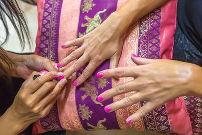Cropped hands of woman applying nail polish on customer hand