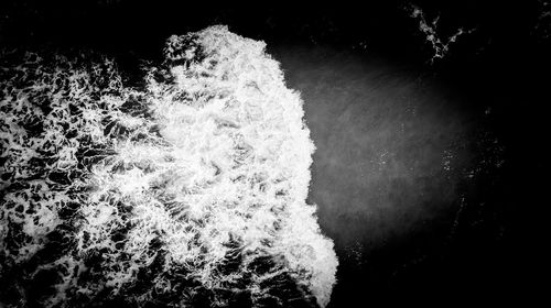 Close-up of water splashing in sea against sky