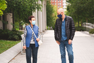 Friends walking on walkway in city