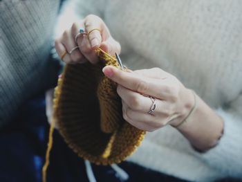 High angle midsection of woman knitting wool at home