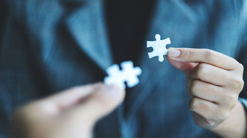 Midsection of woman holding jigsaw puzzle