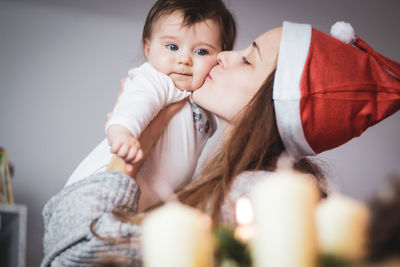 Mother kissing her baby at christmas time