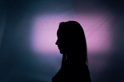 Portrait of silhouette woman against gray background