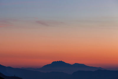 Scenic view of silhouette mountains against sky at sunset