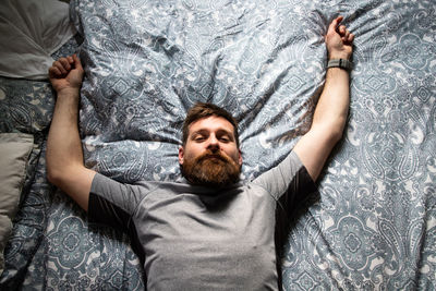 High angle portrait of man lying on bed