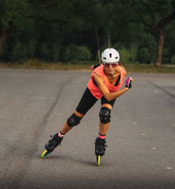 Full length of woman inline skating on road
