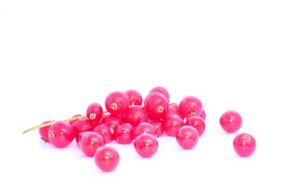 Close-up of red berries over white background