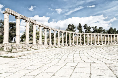 View of columns against cloudy sky